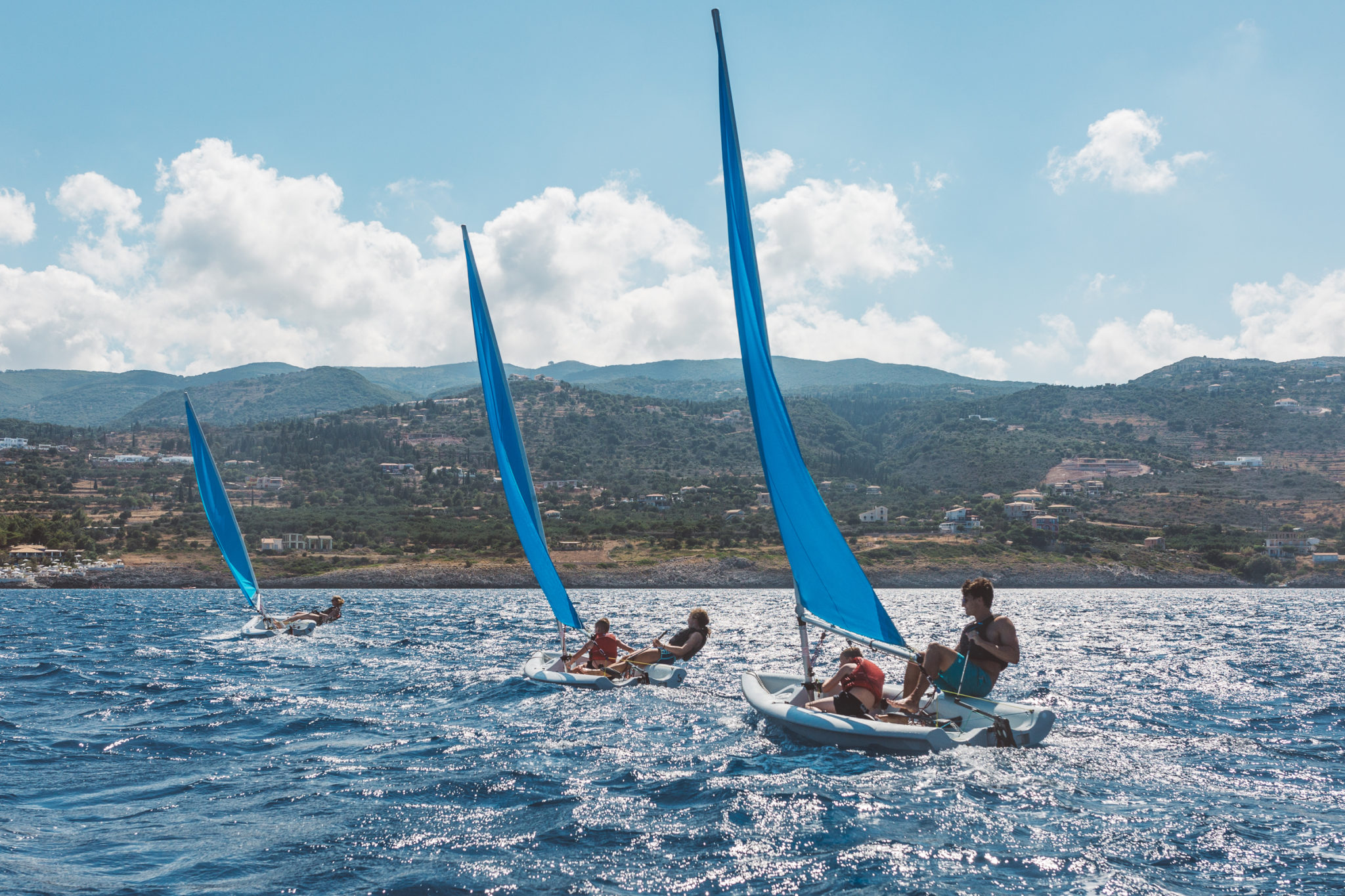 Group of young kids learning to sail