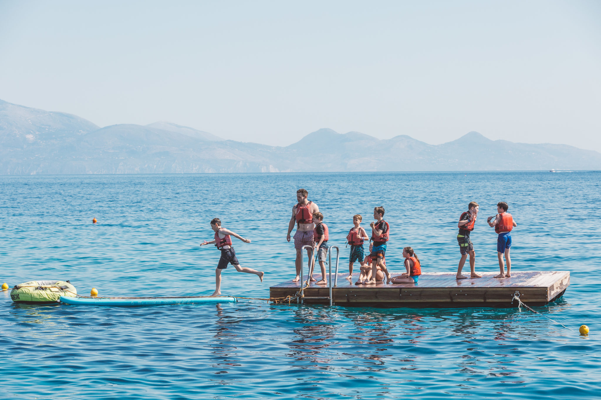 Kids playing on a pontoon on the sea