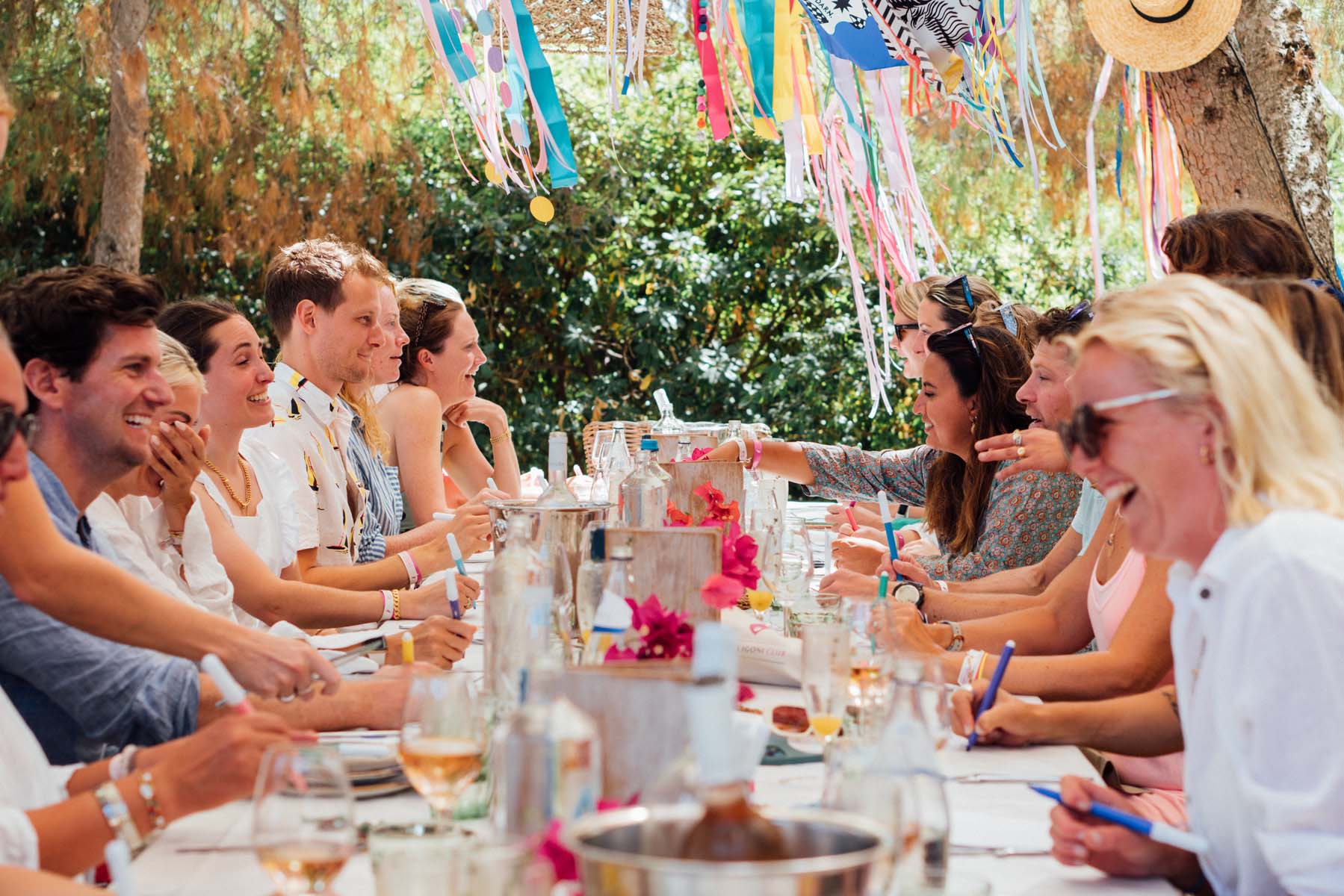 People seated at a long table with summery festival decorations