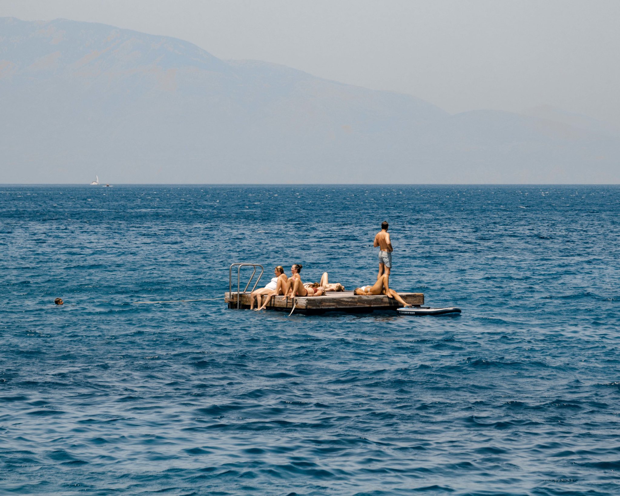 People sunbathing on the pontoon at sea