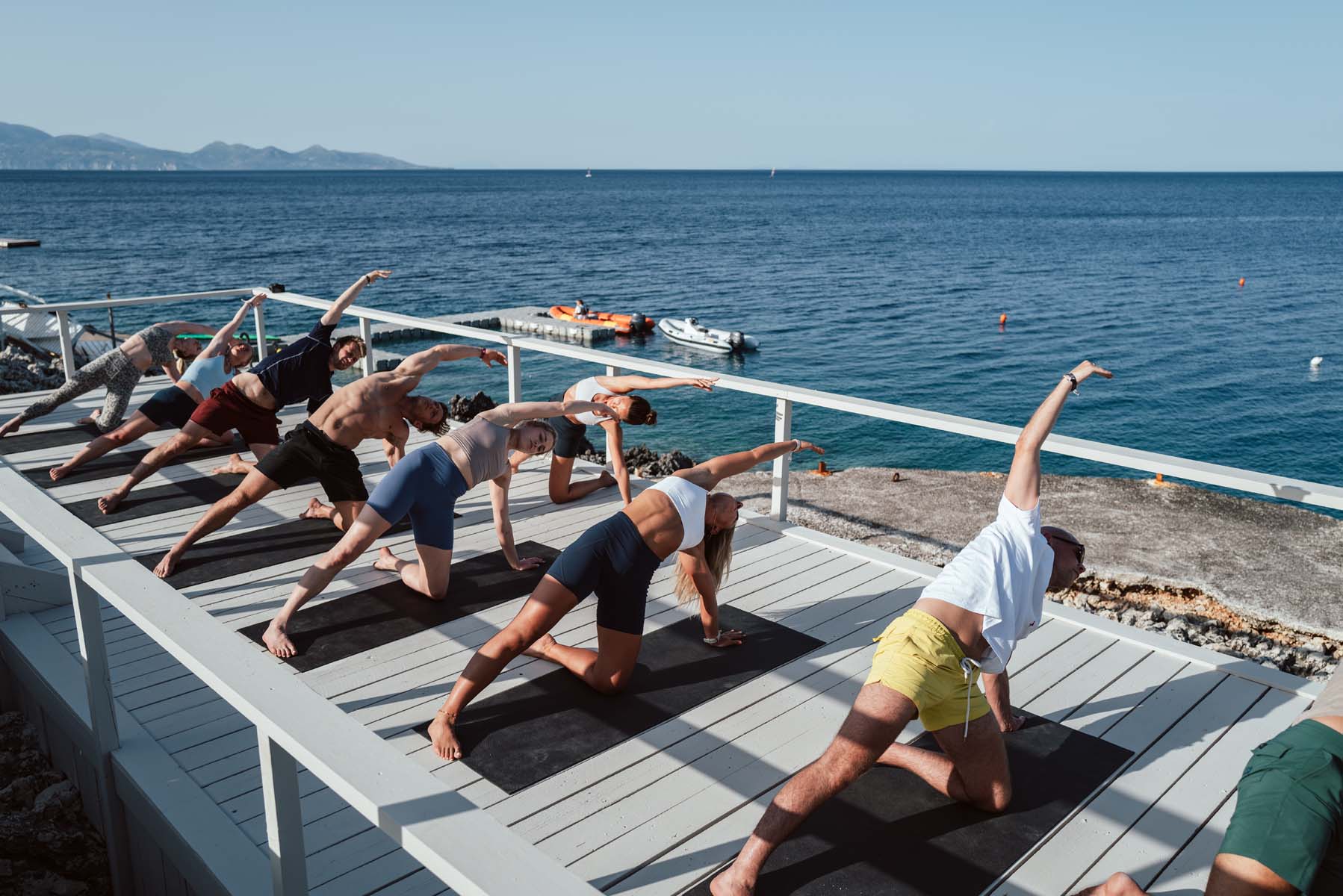 A yoga class by the white wash deck overlooking the sea