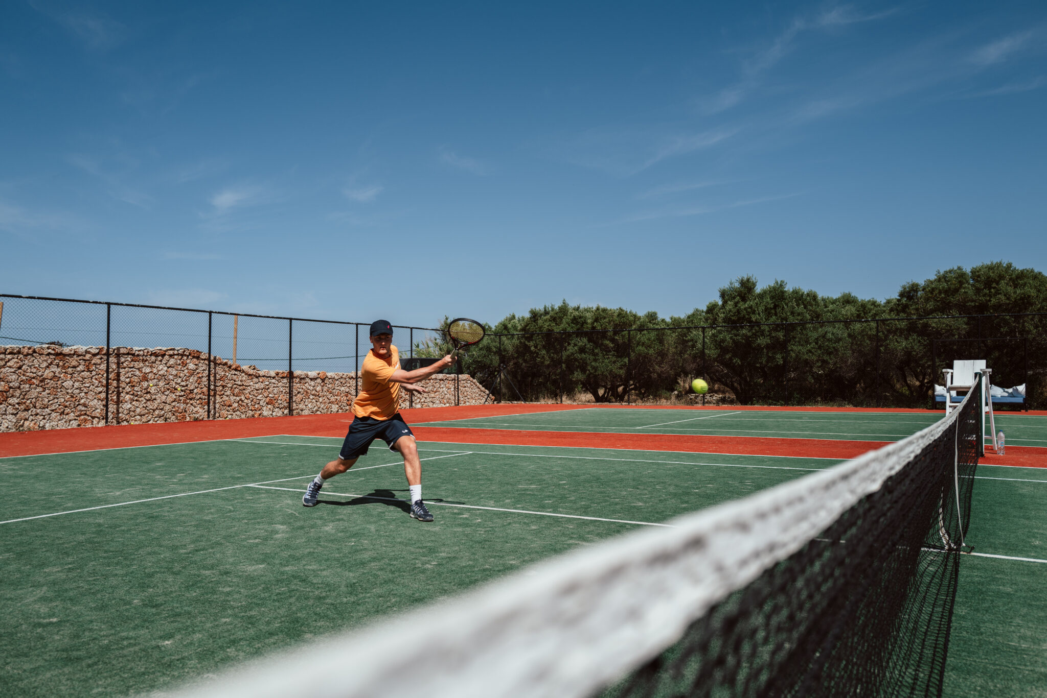 boy playing tennis on court